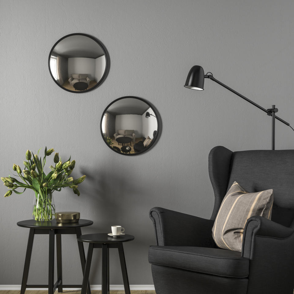 A living room with two convex mirrors hanging on the wall