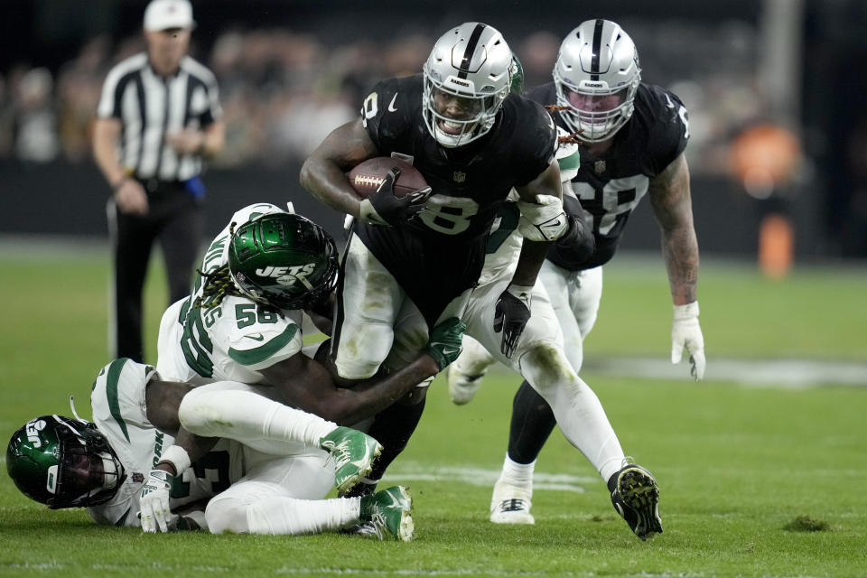 Las Vegas Raiders running back Josh Jacobs (8) runs with the ball as New York Jets linebacker Quincy Williams (56) defends during the second half of an NFL football game Sunday, Nov. 12, 2023, in Las Vegas. (AP Photo/John Locher)