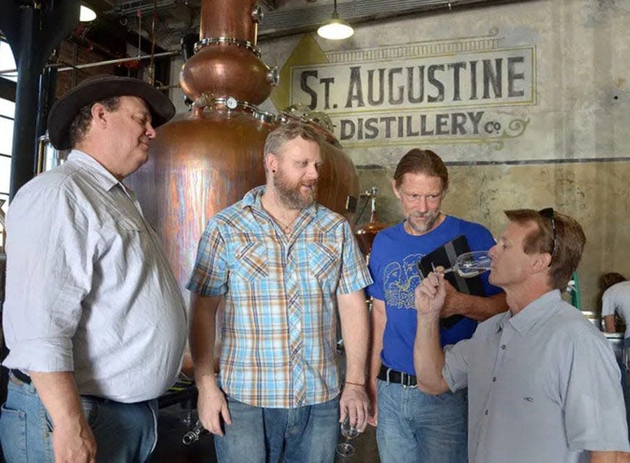 St. Augustine Distillery Company consultant David Pickerell, head of production Brendan Wheatley and CEO Phil McDaniel watch as the company's CFO Mike Diaz samples their first batch on bourbon on Dec. 9, 2013.
