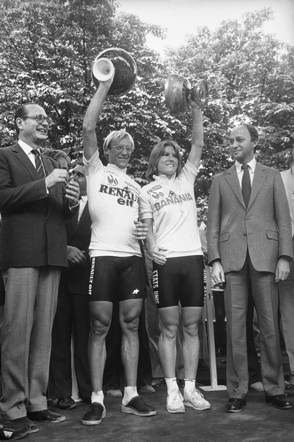 FILE - In this Sunday, July 23, 1984 file photo, Laurent F. Fignon, left, of France, and Marianne Martin of Boulder, Colorado, hold up their trophies in Paris after winning the men's and women's Tour de France cycling races. A women's version of the Tour de France will be held in 2022 with a start on Paris' iconic Champs-Elysees boulevard after the conclusion of the men's race, organizers announced Thursday June 17, 2021. (AP Photo/Steven, File)