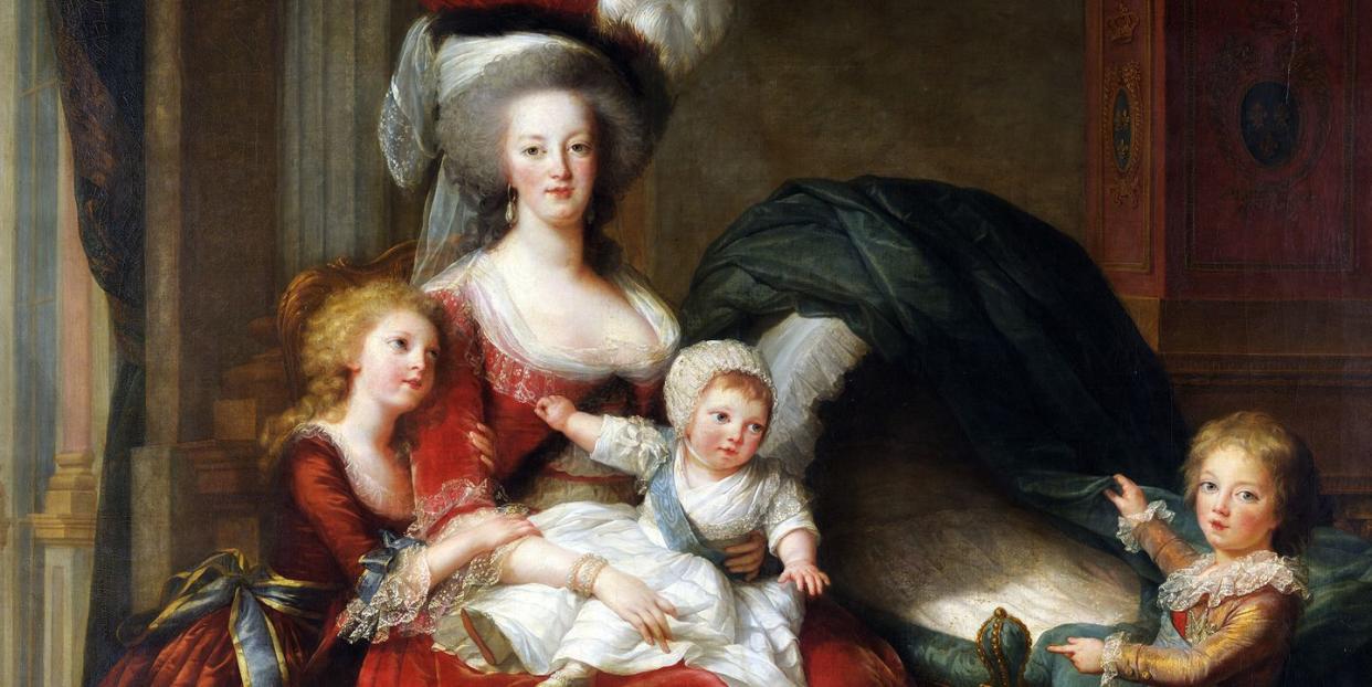 marie antoinette sits and holds one of her children on her lap, another of her children hugs her, and a third stands nearby at the end of baby crib