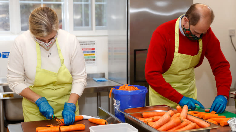 Two people prepping carrots