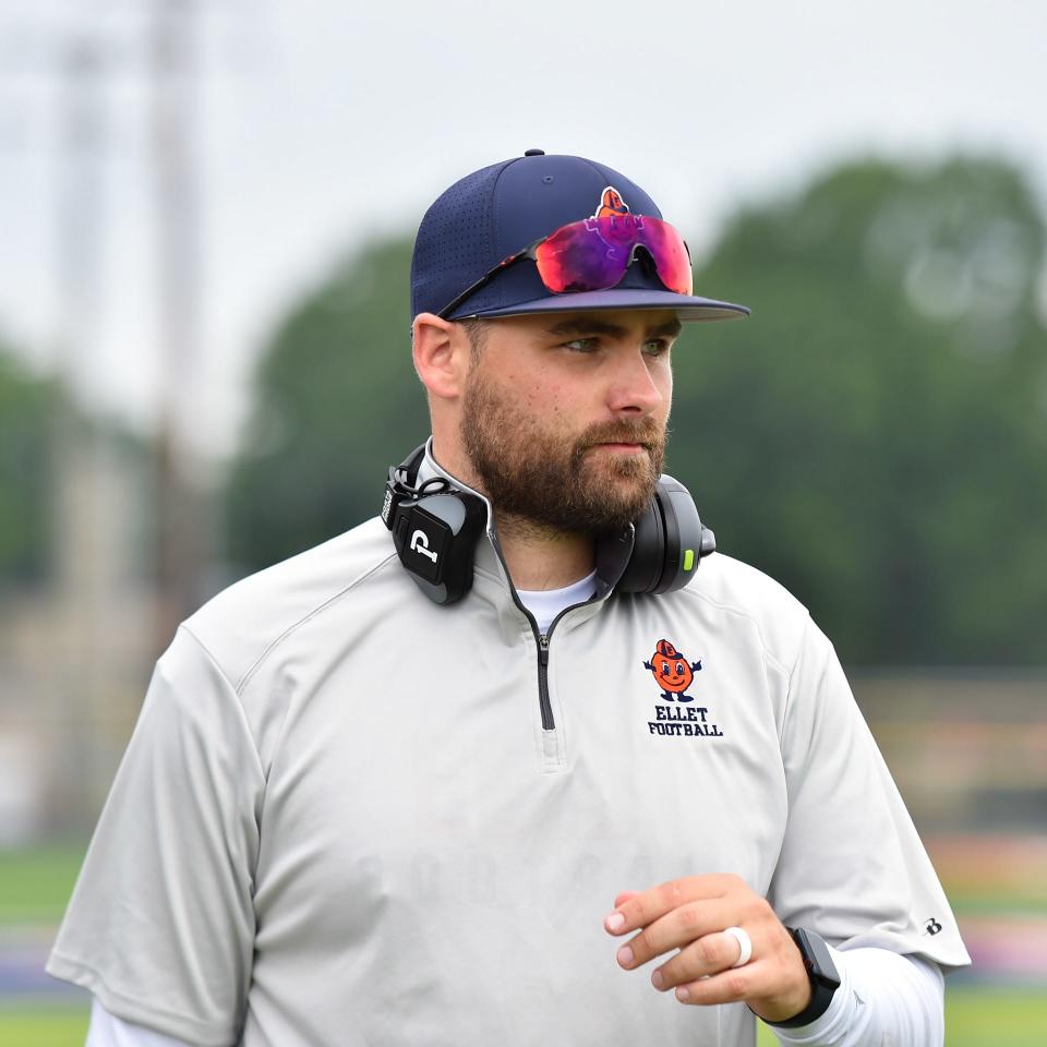 Ellet football coach John Daraio walks the field during a 7-on-7 scrimmage with Coventry, Rootstown and Kent Roosevelt in July 2023.