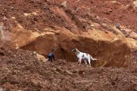 <p>Dogs roam along the mud and debris days following the partial collapse of a hillside that swept away hundreds of homes in a neighborhood of the capital Freetown on Aug. 19, 2017.<br> (Photo: Seyllou/AFP/Getty Images) </p>