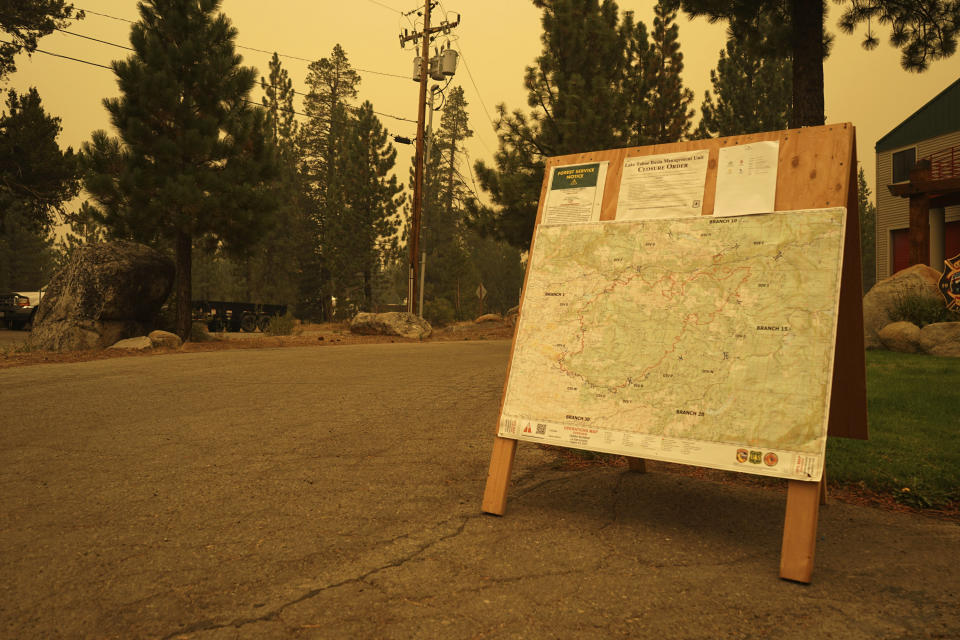 A U.S. Forest Service bulletin board displays information about closures and evacuations at the Lake Valley Fire District Headquarters in Meyers, Calif., on Thursday, Aug. 26, 2021. California weather is heating up and winds are shifting as more than 14,000 firefighters battled wildfires up and down the state, including a major blaze they hoped to keep out of the Lake Tahoe resort region. (AP Photo/Sam Metz)