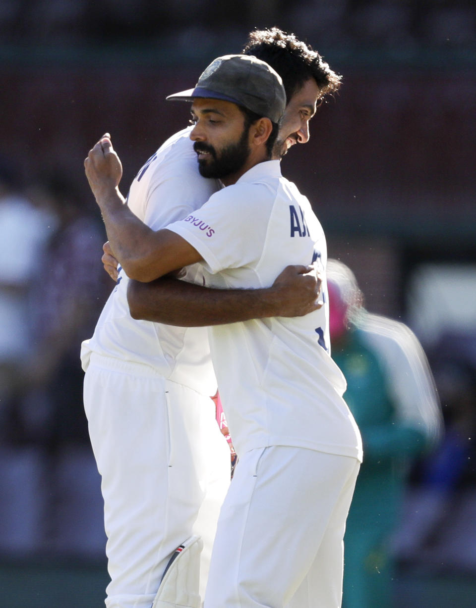 India's Ravichandran Ashwin is embraced by his captain Ajinkya Rahane, left, following play on the final day of the third cricket test between India and Australia at the Sydney Cricket Ground, Sydney, Australia, Monday, Jan. 11, 2021. The test ended in a draw and the series is at 1-1 all with one test to play. (AP Photo/Rick Rycroft)