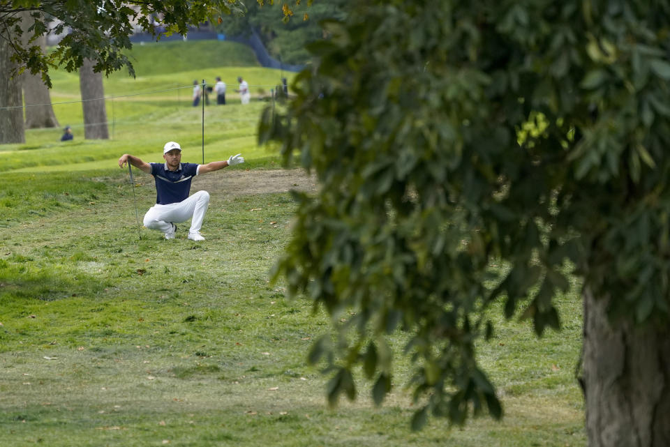 Xander Schauffele, of the United States, gestures to his caddie before hitting out of the rough on the 13th hole during the first round of the US Open Golf Championship, Thursday, Sept. 17, 2020, in Mamaroneck, N.Y. (AP Photo/Charles Krupa)