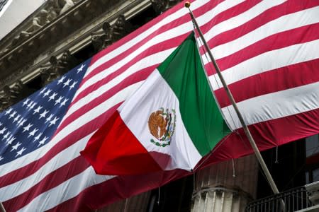 FILE PHOTO: The flag of Mexico changes in front of a large U.S. flag in front of the New York Stock Exchange