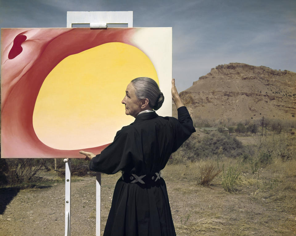 This 1960 photograph by Tony Vacarro shows artist Georgia O'Keeffe posing with her painting "Pelvis Series, Red with Yellow" in Taos Pueblo, New Mexico. Vaccaro, 97, was thrown into WWII with the 83rd Infantry division which fought, like Charles Shay, in Normandy, and then came to Schmetz's doorstep for the Battle of the Bulge. On top of his military gear, he also carried a camera, and became a fashion and celebrity photographer after the war. COVID-19 caught up with him last month. Like everything bad life threw at him, he shook it off, attributing his survival to plain "fortune." (Photo courtesy Tony Vaccaro via AP)