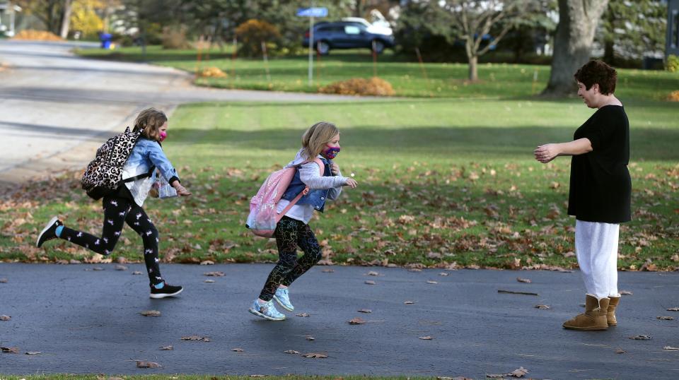 Sara Walrath greeted her children Sammie, now 10, left, and Charlotte, now 7, as they got off the school bus on Nov. 12, 2020.  At the time, schooldays were short due to COVID precautions.