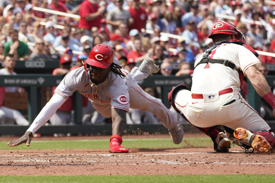 Cincinnati Reds' Elly De La Cruz, left, scores past St. Louis Cardinals catcher Andrew Knizner during the seventh inning of a baseball game Saturday, June 10, 2023, in St. Louis. (AP Photo/Jeff Roberson)