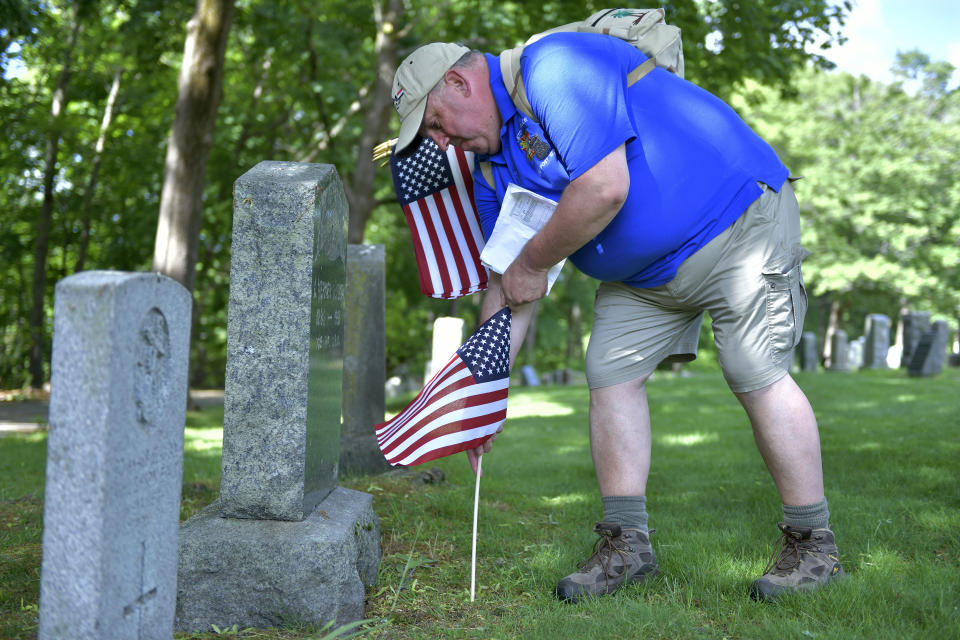 Craig DeOld, a retired Army Captain, and commander of the Boston Police VFW, replaces flags at veteran's graves Thursday, May 27, 2021, in the Fairview Cemetery in Boston. After more than a year of isolation, American veterans are embracing plans for a more traditional Memorial Day. “We’re breathing a sigh of relief that we’ve overcome another struggle, but we’re also now able to return to what this holiday is all about — remembering our fallen comrades.” (AP Photo/Josh Reynolds)
