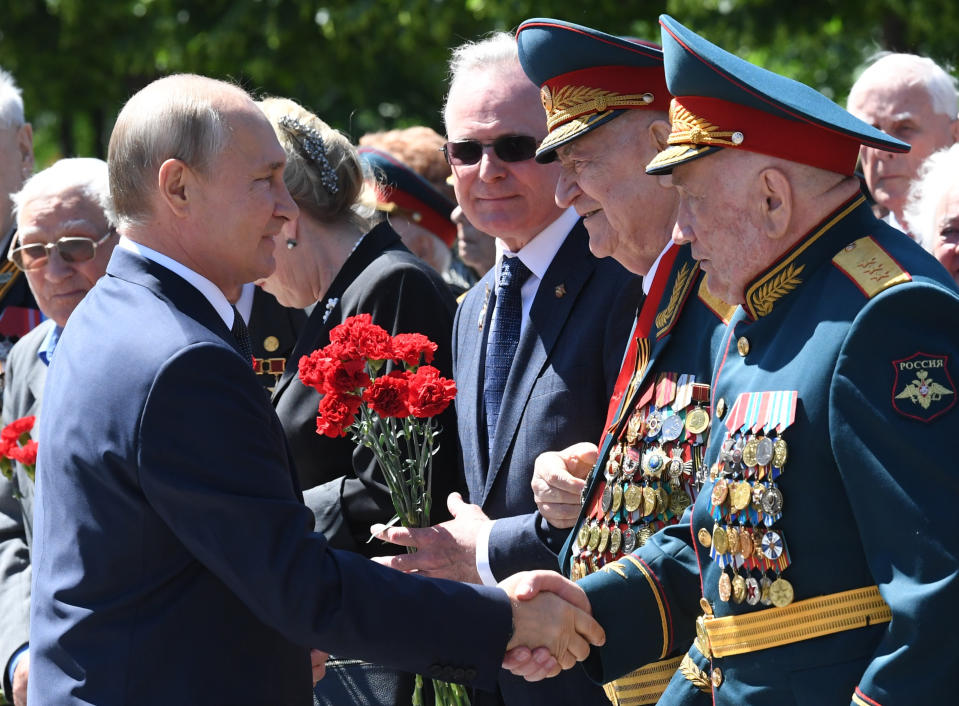 FILE - In this file photo taken on Monday, June 22, 2020, Russian President Vladimir Putin, left, greets WWII veterans during a wreath laying ceremony at the Tomb of Unknown Soldier in Moscow, marking the 79th anniversary of the Nazi invasion of the Soviet Union. A massive military parade that was postponed by the coronavirus will roll through Red Square this week to celebrate the 75th anniversary of the end of World War II in Europe, even though Russia is continuing to register a steady rise in infections. (Alexei Nikolsky, Sputnik, Kremlin Pool Photo via AP, File)