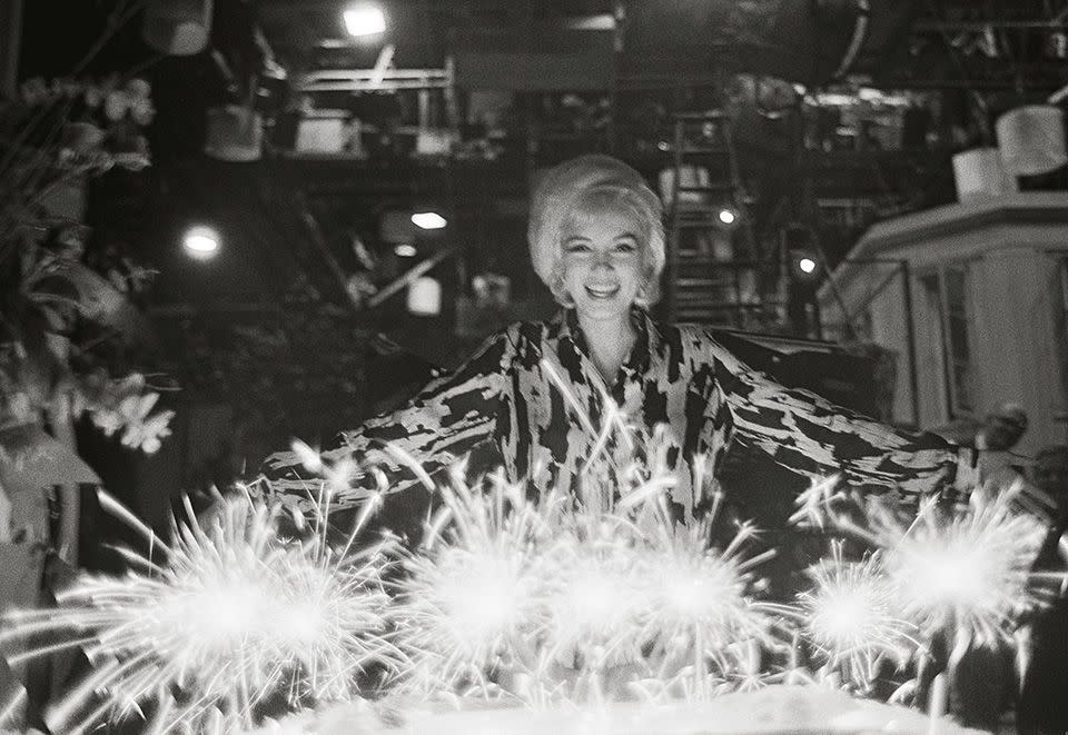 <p>"A huge birthday cake was brought in with sparklers for candles, and Marilyn posed behind it looking joyful and appreciative." </p>