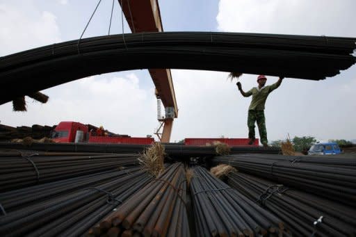 A worker unloads steel bars outside a factory in Huaibei, east China's Anhui province. China's exports grew 1% in July year-on-year to 176.9 billion USD, official data showed on August 10, in a fresh sign of weakness in the world's second-largest economy