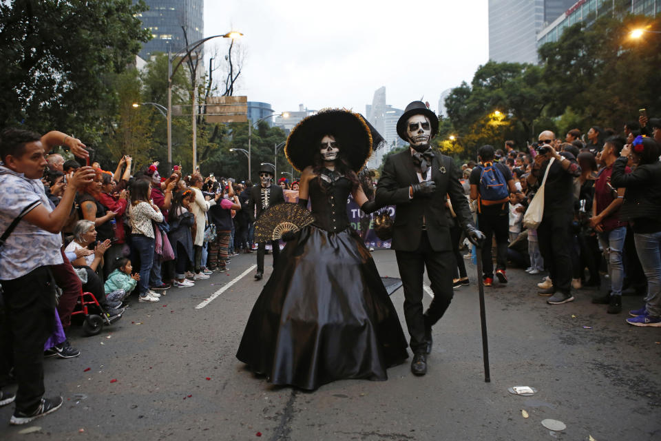 People dressed as Catrinas parade down Mexico City's iconic Reforma avenue during celebrations for the Day of the Dead in Mexico, Saturday, Oct. 26, 2019. (AP Photo/Ginnette Riquelme)