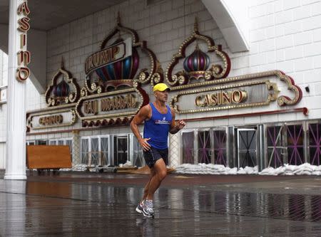 A jogger runs past the sandbagged and closed Trump Taj Mahal Casino on the boardwalk at Atlantic City, New Jersey in this file photo from August 27, 2011. REUTERS/Jason Reed/Files