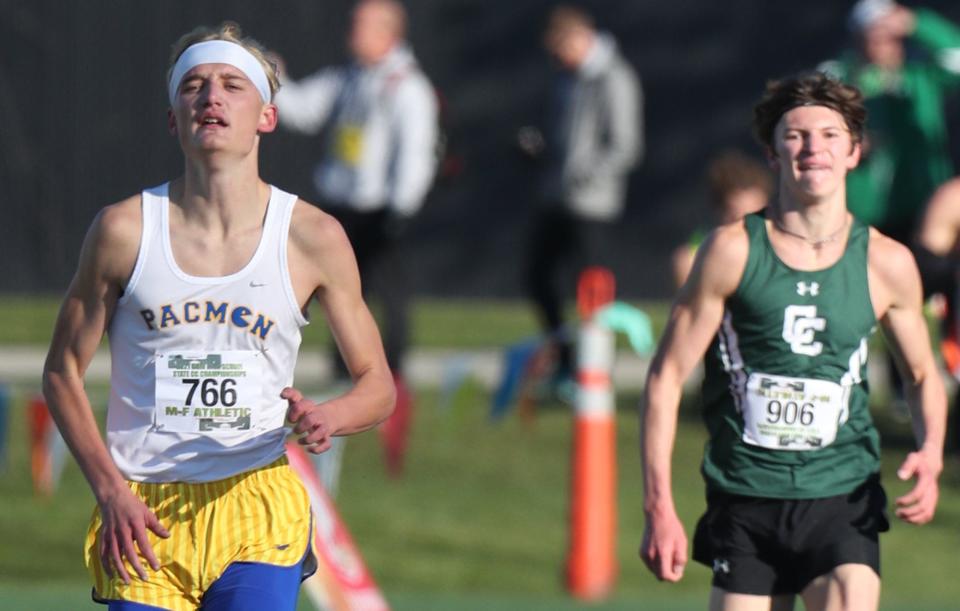 East Canton's Gabe Shilling runs ahead of Canton Central's Ian Paul as they finish fourth and fifth at the Div. III Boys Cross Country Championship at Fortress Obetz.