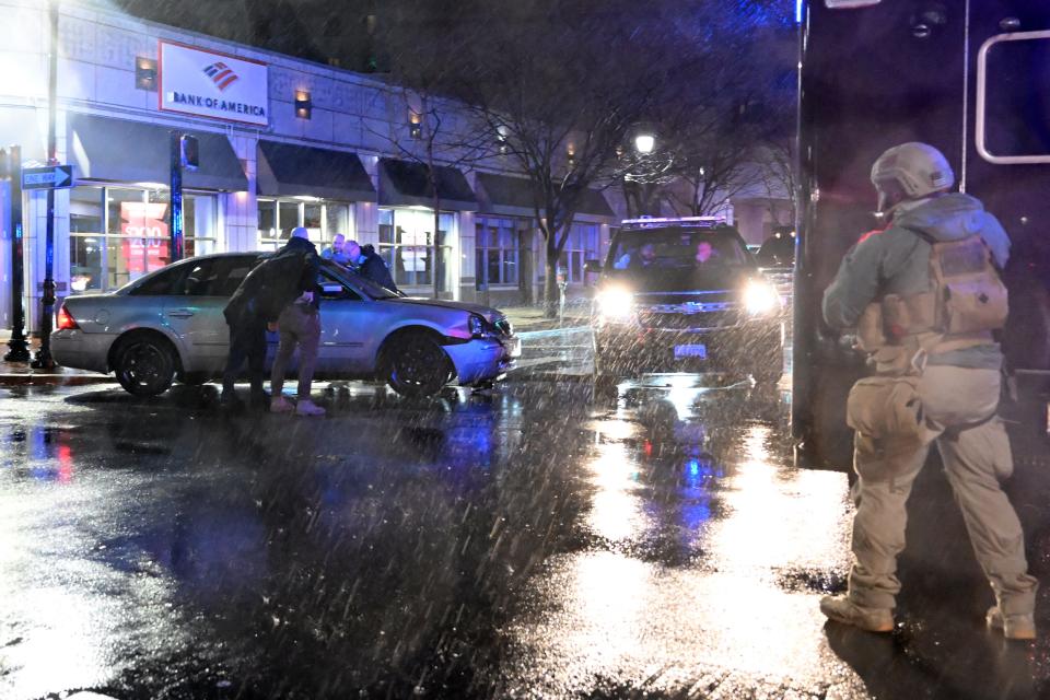 Members of the US Secret Service rush to a car, after it hit a motorcade SUV, as U.S. president Joe Biden was leaving his campaign headquarters in Wilmington, Delaware on December 17, 2023. (Photo by ANDREW CABALLERO-REYNOLDS / AFP)