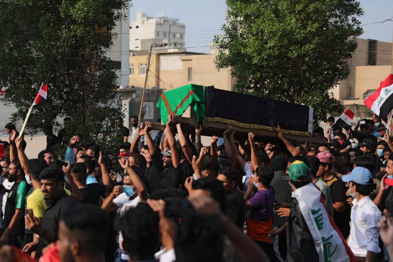 Mourners carry the coffin of a protester, who was killed overnight at a protest, during a funeral in the holy city of Kerbala