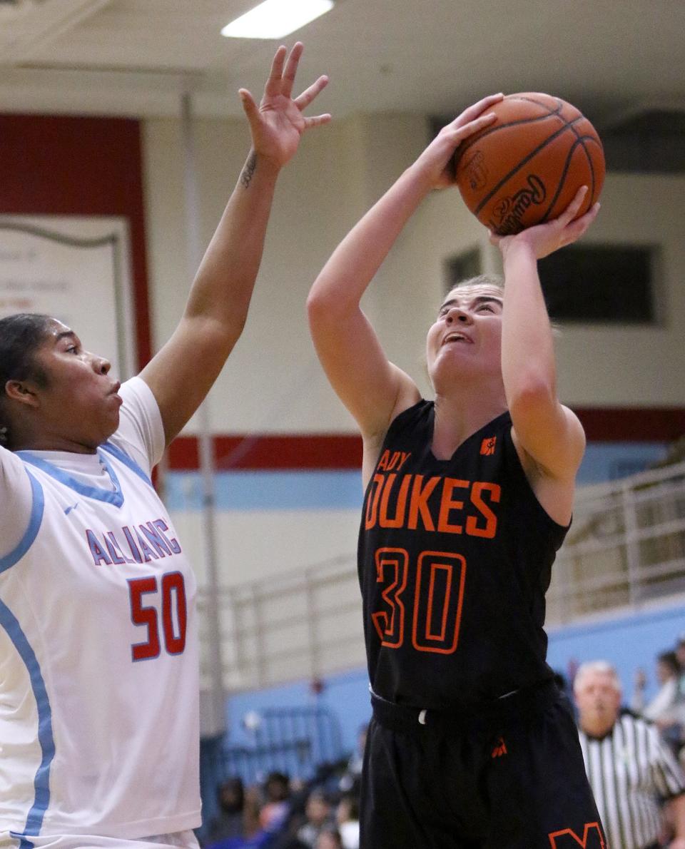 Marlington's Elizabeth Mason (right) puts up a shot defended by Alliance's X'Zaryia Fannin during action Wednesday night.