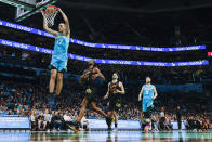 Charlotte Hornets forward Aleksej Pokusevski (17) dunks ahead of Cleveland Cavaliers forwards Evan Mobley (4) and Georges Niang (20) as Charlotte Hornets forward Davis Bertans (9) looks on during the first half of an NBA basketball game in Charlotte, N.C., Wednesday, March 27, 2024. (AP Photo/Nell Redmond)