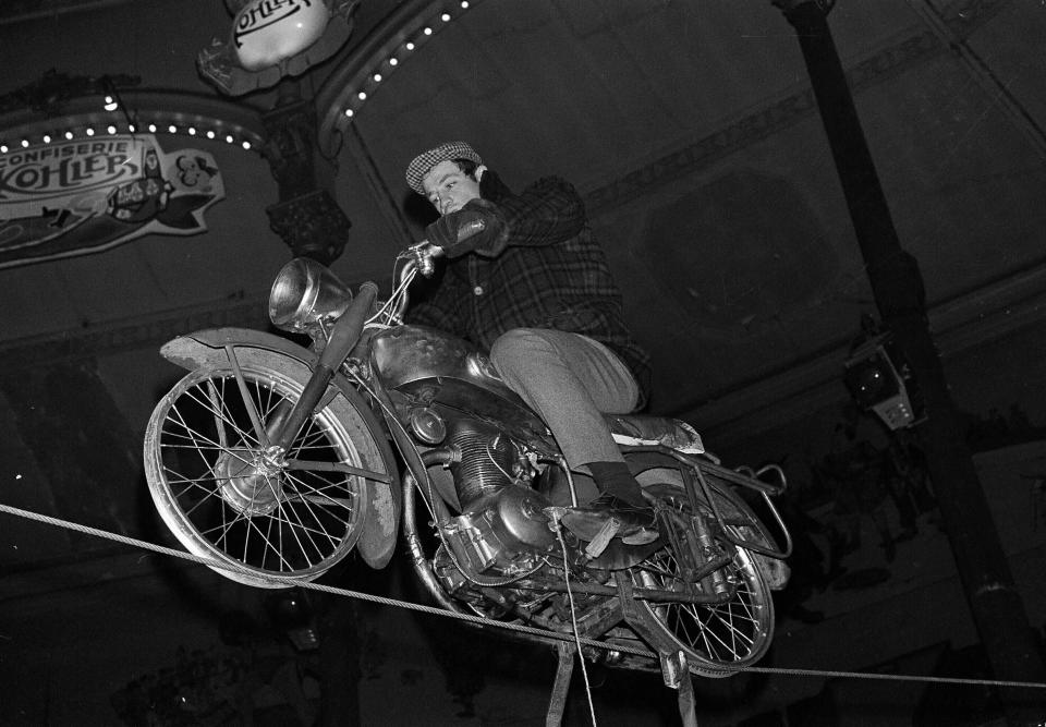 ARCHIVO – en esta fotografía del 5 de febrero de 1963 el actor francés Jean-Paul Belmondo ensaya su acto en motocicleta sobre una cuerda fija en el Circo Medrano en París. El astro de la Nueva Ola francesa Jean-Paul Belmondo ha muerto, informó la oficina de su abogado el 6 de septiembre de 2021. (Foto AP/Jacques Marqueton, archivo)