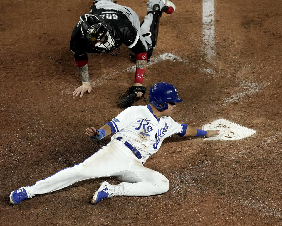 Kansas City Royals' Nicky Lopez beats the tag by Chicago White Sox catcher Yasmani Grandal to score on a two-run double by Whit Merrifield during the eighth inning of a baseball game Monday, May 16, 2022, in Kansas City, Mo. (AP Photo/Charlie Riedel)