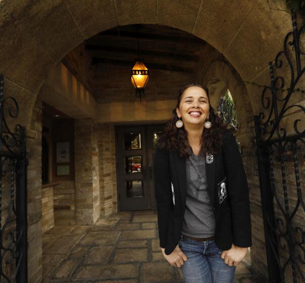 A woman standing in an archway and smiling