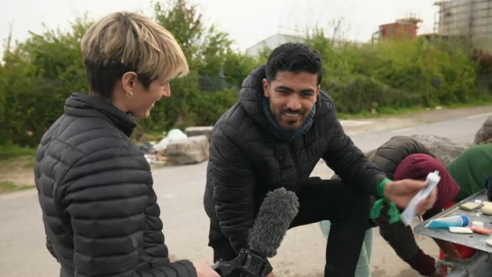 A man being interviewed by BBC reporter Fiona Irving while he uses a communal sink