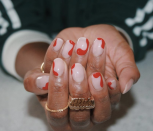 <p>For an abstract and understated manicure, try red swirls in all shapes and sizes around a pale pink nail.</p>