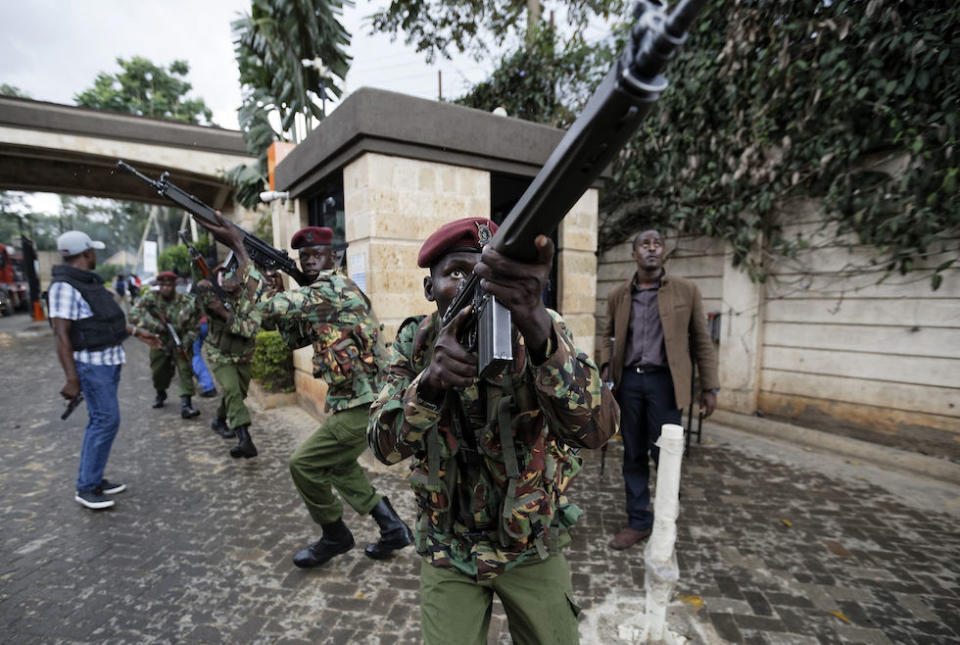 Kenyan security forces aim their weapons up at buildings as they run through a hotel complex in Nairobi, Kenya (Picture: AP)