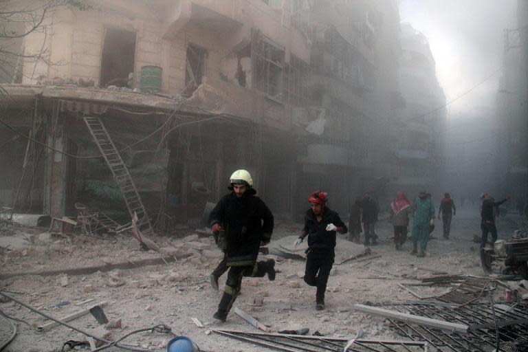 Syrian emergency responders rush following a reported barrel bomb attack by regime forces in the Al-Muasalat area of Aleppo, on November 6, 2014