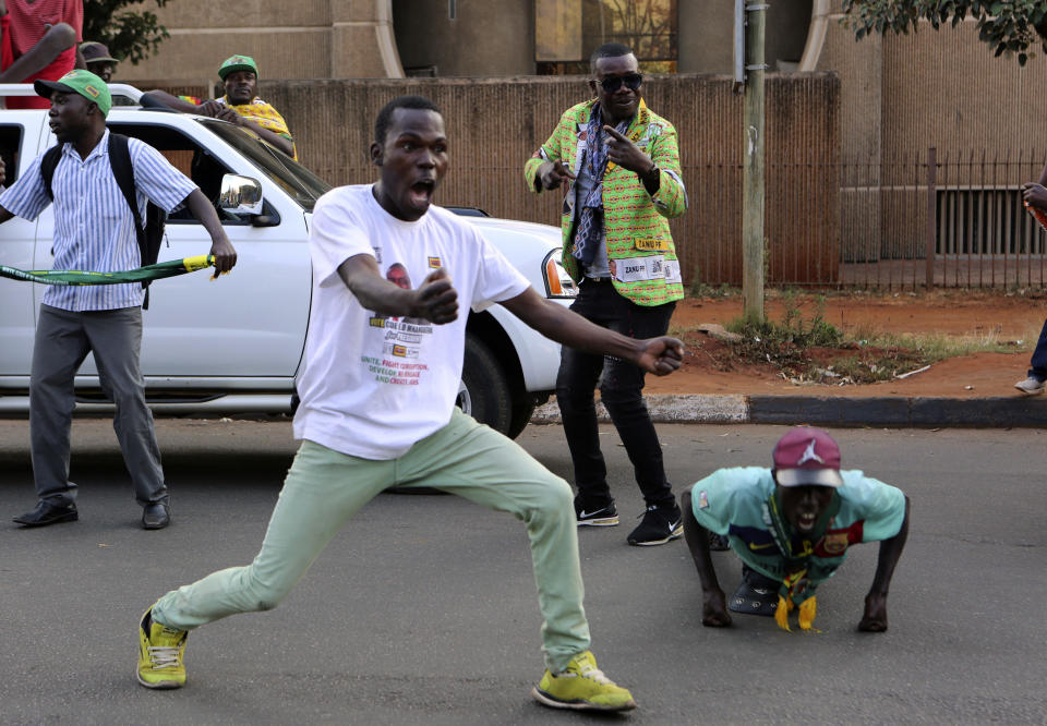 Supporters of Zimbabwean President Emmerson Mnangagwa celebrate in Harare, Friday, August, 24, 2018. Zimbabwe's constitutional court on Friday unanimously upheld Mnangagwa's narrow victory in last month's historic election after the opposition alleged vote-rigging, saying "sufficient and credible evidence" had not been produced. That means the inauguration will be held within 48 hours, likely on Sunday, as Zimbabwe moves into a new era after Robert Mugabe's 37-year rule.(AP Photo/Tsvangirayi Mukwazhi)