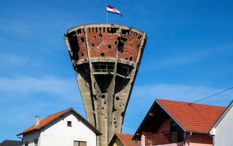 Vukovar water tower, ruined in war, stands tall beside newly rebuilt housing - Credit: Getty