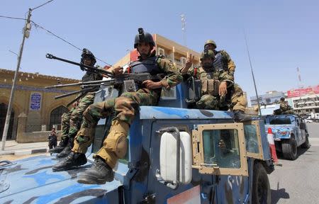 Iraqi policemen take up positions during security deployment in Najaf, July 18, 2014. REUTERS/Alaa Al-Marjani