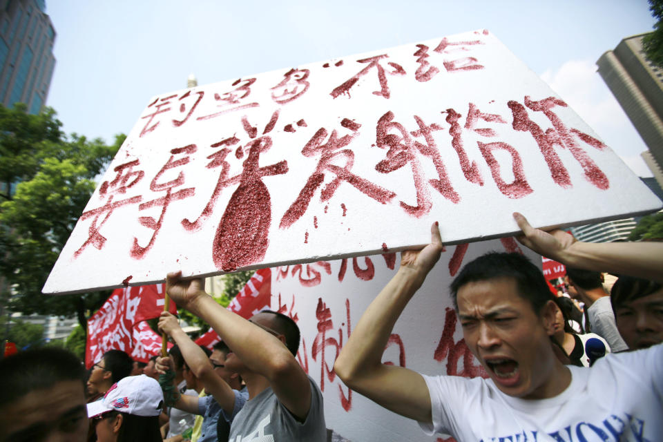 Protesters shout anti-Japan slogans while holding a banner reading “We won’t give Diaoyu Island, but if you want the bomb, we want to give it to you” near the Japanese Consulate General Tuesday, Sept. 18, 2012, in Shanghai, China. The 81st anniversary of a Japanese invasion brought a fresh wave of anti-Japan demonstrations in China on Tuesday, with thousands of protesters venting anger over the colonial past and a current dispute involving contested islands in the East China Sea. (AP Photo/Eugene Hoshiko)