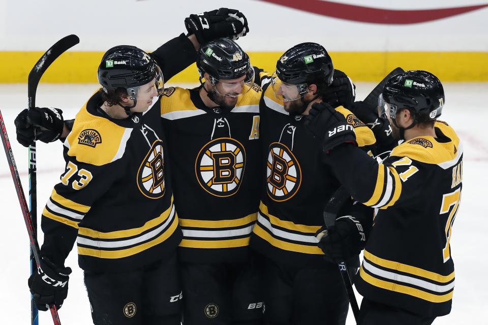 Boston Bruins' Craig Smith (12) celebrates his hat-trick goal with teammates Charlie McAvoy (73), David Krejci (46) and Taylor Hall (71) during the third period of an NHL hockey game against the Buffalo Sabres, Saturday, May 1, 2021, in Boston. (AP Photo/Michael Dwyer)