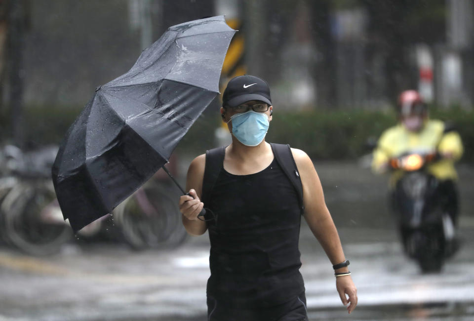 A man struggles with his umbrella against powerful gusts of wind generated by Typhoon Chanthu in Taipei, Taiwan, Sunday, Sept. 12, 2021. Typhoon Chanthu drenched Taiwan with heavy rain Sunday as the storm’s center passed the island’s east coast heading for Shanghai. (AP Photo/Chiang Ying-ying)