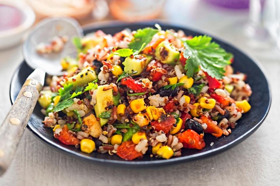 a plate of rice and beans with corn and vegetables