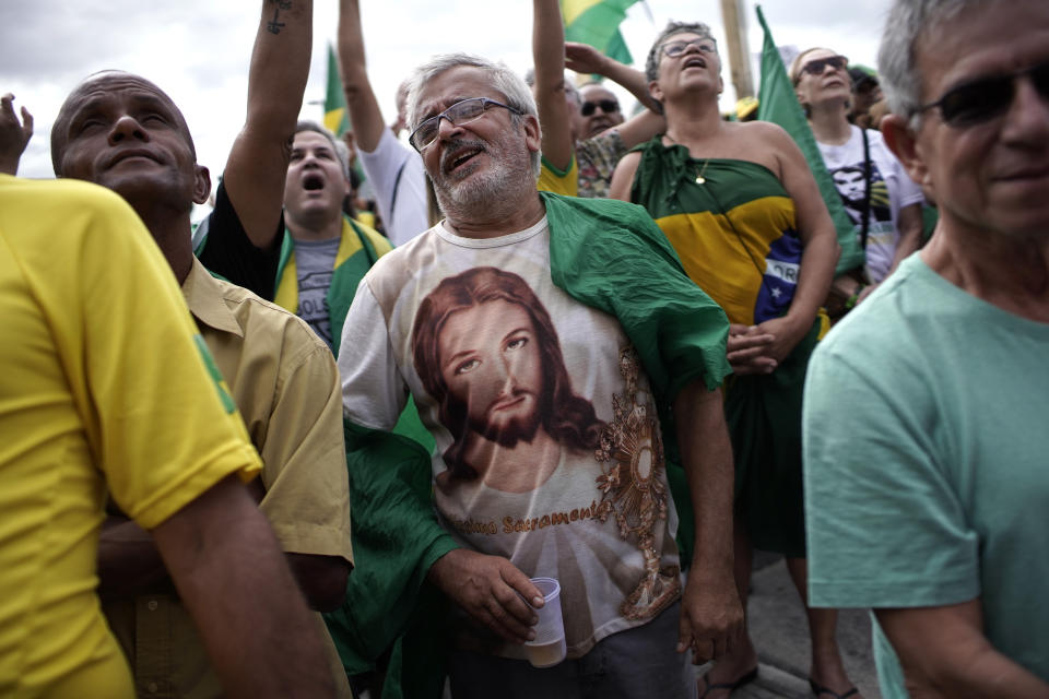 A man wearing a Jesus T-shirt shouts slogans during a rally in favor of Brazil's President Jair Bolsonaro on Copacabana beach in Rio de Janeiro, Brazil, Sunday, May 26, 2019. The pro-Bolsonaro rally follows anti-government protests against cuts in the education budget as the president also battles an uncooperative Congress, a family corruption scandal and falling approval ratings after five months in office. (AP Photo/Silvia Izquierdo)