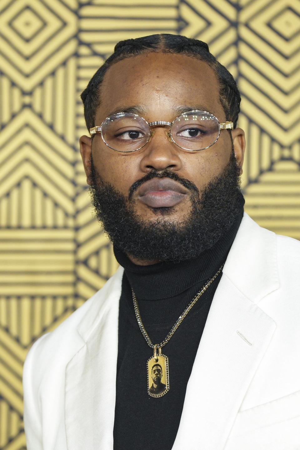 El director Ryan Coogler porta un collar con la imagen de Chadwick Boseman a su llegada a la alfombra roja de “Black Panther: Wakanda Forever” en Londres, el jueves 3 de noviembre de 2022. (Foto Scott Garfitt/Invision/AP)