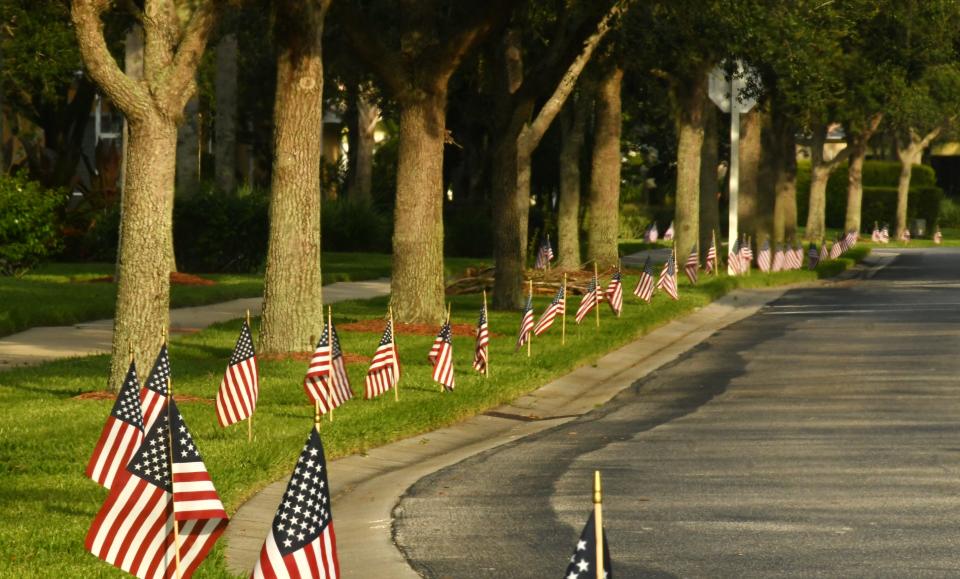 U.S. flags line the roadside in front of homes in The Lakes at Waterstone development in Palm Bay.