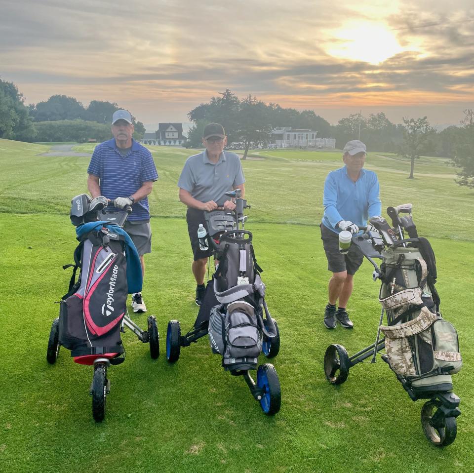 From left, Kevin Tivnan, Ron Lohnes and Bruce Chansky push their carts down the fairway at Green Hill.