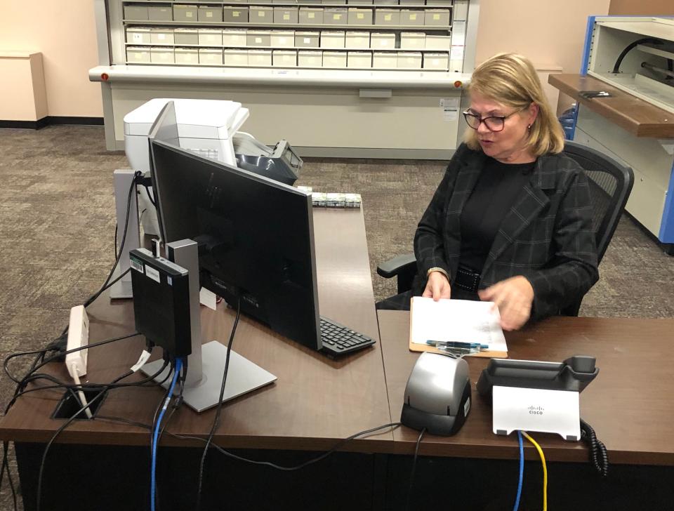 At one of the desks in her office, St. Joseph County Clerk Amy Rolfes demonstrates how election workers compare written signatures on ballot petitions with Indiana's records of signatures for the past 10 years.