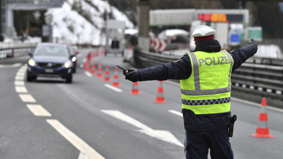 A policeman selects a car coming from Italy at the autobahn near Gries am Brenner on Tuesday, March 10, 2020. Austria authorities started on random checks of arriving vehicles at the border crossings with Italy in reaction to the outbreak of the new coronavirus in Europe, particularly in Italy. As part of the move, officials measure the temperatures of some passengers in cars, trucks and buses. For most people, the new coronavirus causes only mild or moderate symptoms, such as fever and cough. For some, especially older adults and people with existing health problems, it can cause more severe illness, including pneumonia. (AP Photo/Kerstin Joensson )