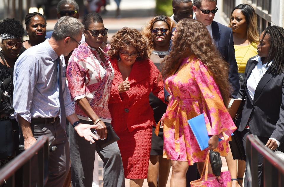 Former U.S.  Rep. Corrine Brown (center, in red) gives a thumbs up after leaving Jacksonville's federal courthouse in May.