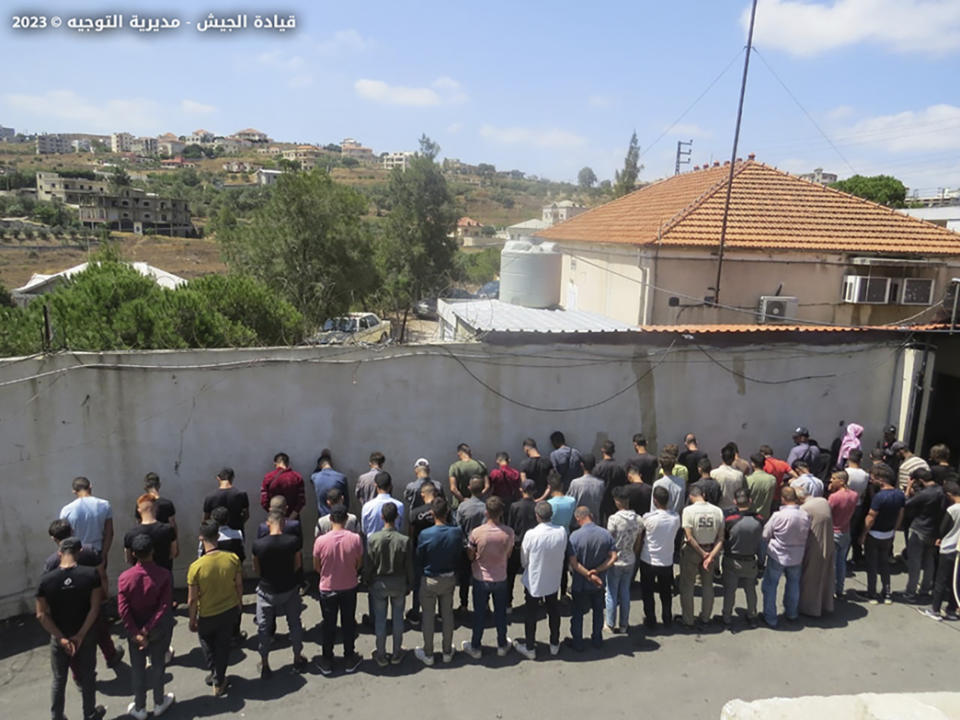 In this photo released on Aug. 9, 2023, by the Lebanese Army official website, the Lebanese Army lines up a group of Syrians accused of illegally crossing into Lebanon from Syria by way of smugglers in the town of Shadra, northern Lebanon's Akkar province. Lebanon's caretaker Prime Minister Najib Mikati is warning, Thursday, Sept. 7, that Syrian refugees could become a threat to the small Mediterranean nation’s delicate demographic and sectarian balance. Over a thousand Syrian refugees each week are fleeing to Lebanon from their country’s worsening economic and financial conditions.(Lebanese Army Website via AP)