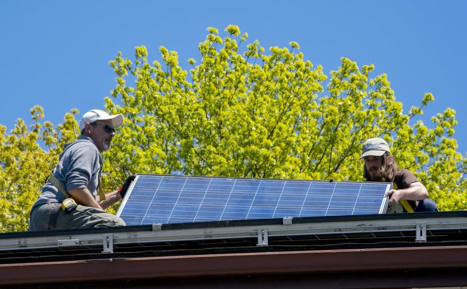 <span class="caption">Workers install solar panels onto a roof in Toronto.</span> <span class="attribution"><span class="source">THE CANADIAN PRESS/Frank Gunn</span></span>