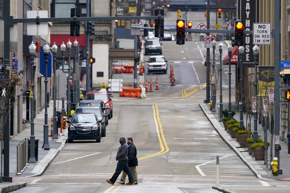 FILE - In this Jan. 17, 2021, file photo, walk across a street in downtown Pittsburgh. Irritated by the sweeping use of executive orders during the COVID-19 crisis, state lawmakers around the U.S. are moving to curb the authority of governors and top health officials to impose emergency restrictions such as mask rules and business shutdowns. (AP Photo/Keith Srakocic, File)